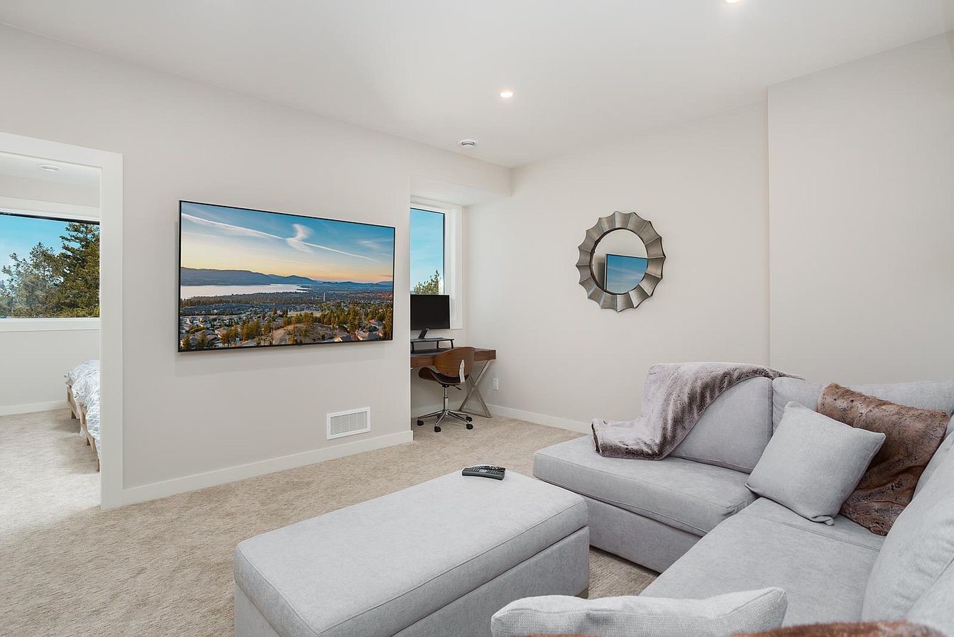 Lower-level family room with sectional, large TV and workstation